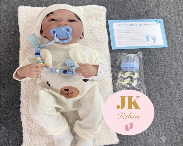 MUÑECO BEBÉ REBORN REALISTA CON OJOS ABIERTOS - SET ENTERIZO DE OSITO CREMA CON GORRITO Y ACCESORIOS CELESTES - 1