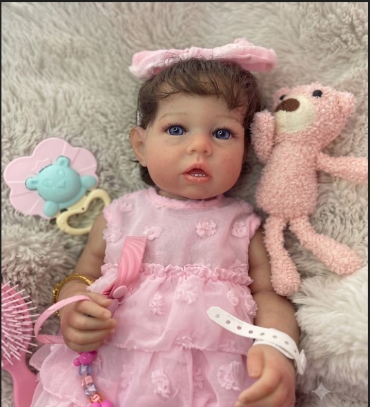 MUÑECA BEBÉ REBORN REALISTA DESPIERTA - VESTIDO ROSA TEXTURIZADO CON DIADEMA DE LAZO, PELUCHE Y ACCESORIOS - 1